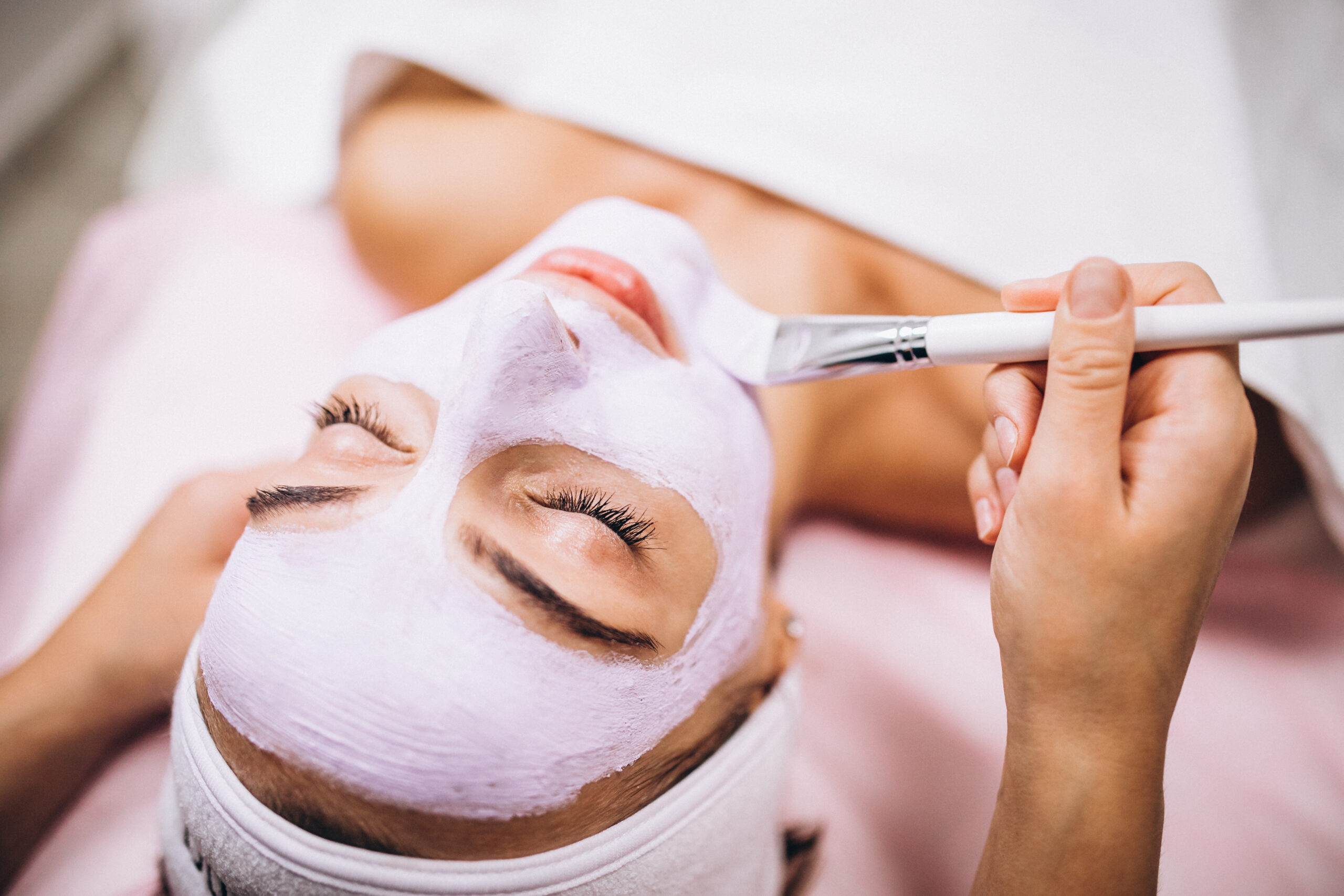 cosmetologist applying mask on a face of client in a beauty salon scaled - Oferta 7